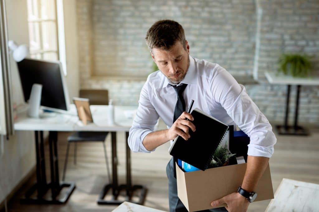 Salarié rangeant ses affaires dans un carton après la rupture de son contrat de travail