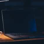 Ordinateur portable fermé et téléphone retourné sur un bureau en soirée, illustrant le droit à la déconnexion des salariés